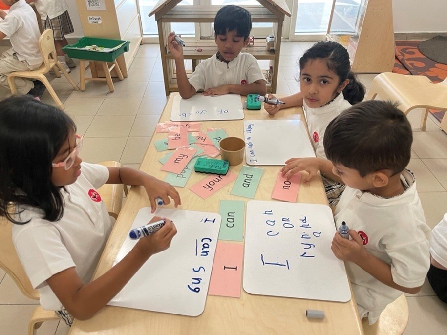 young learners at SIA writing some words in their boards