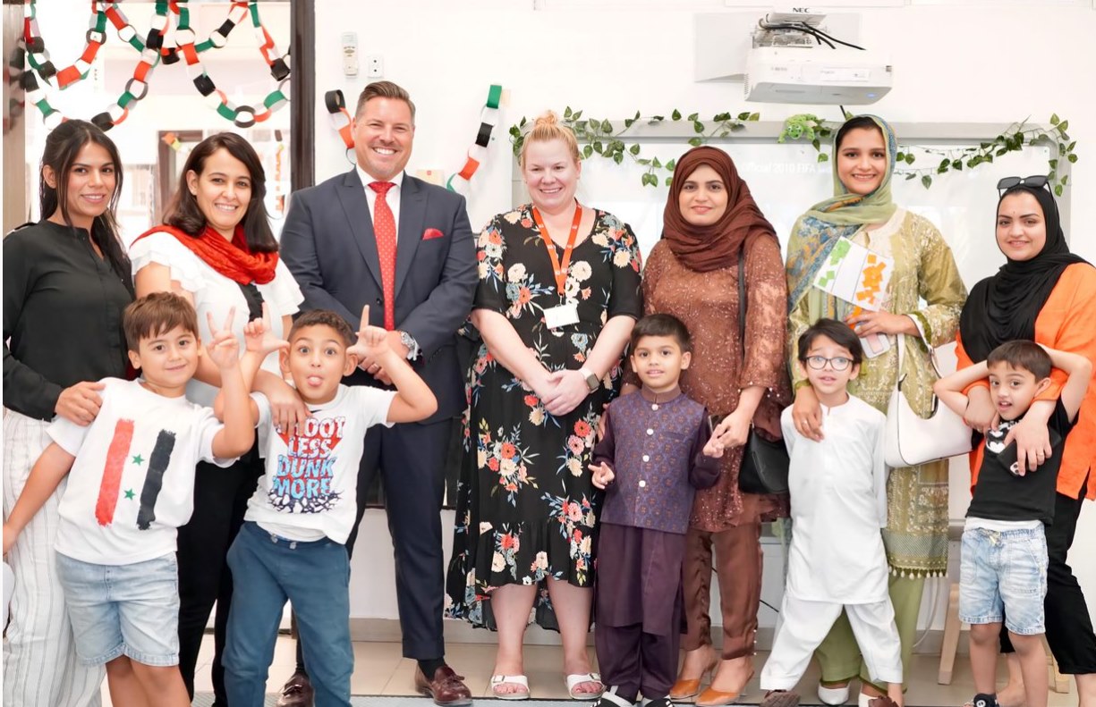 an image of the school principal with learners and their parents